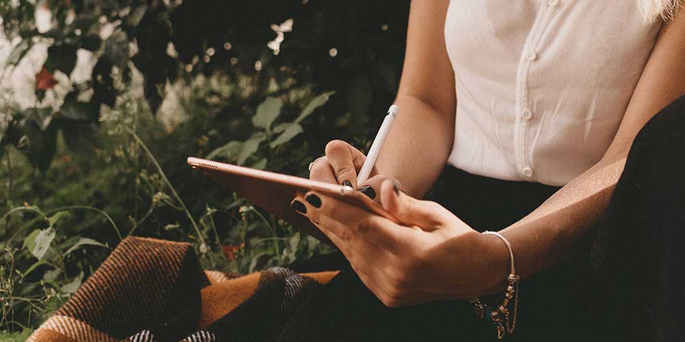 Woman using iPad in garden